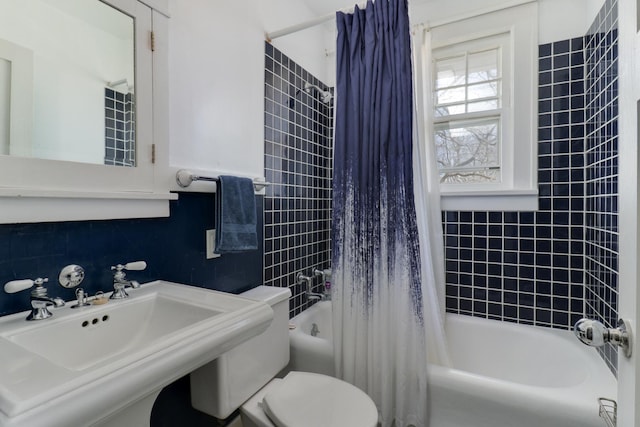 full bathroom with toilet, shower / bathtub combination with curtain, sink, and tile walls