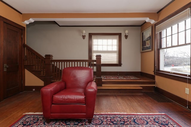 living area with hardwood / wood-style flooring and ornamental molding