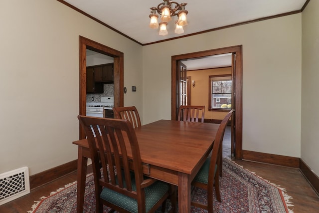 dining area with crown molding, dark hardwood / wood-style flooring, and a notable chandelier