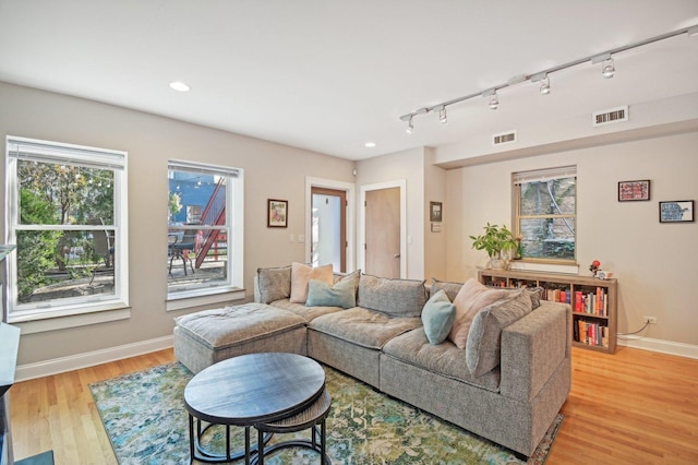 living room with track lighting and light hardwood / wood-style flooring