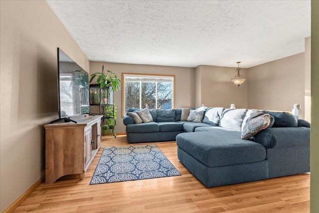 living room featuring a textured ceiling and light wood-type flooring