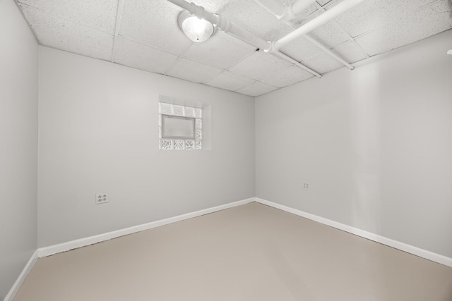 empty room with concrete flooring and a paneled ceiling