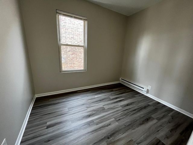 empty room with a baseboard radiator and dark hardwood / wood-style flooring