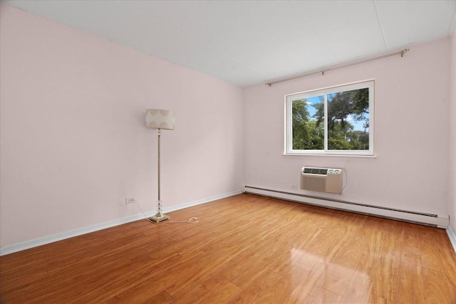 unfurnished room with light wood-type flooring, a wall mounted air conditioner, and a baseboard heating unit