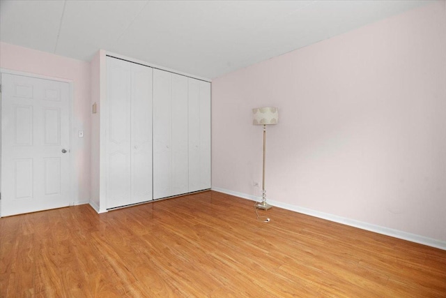 unfurnished bedroom featuring light hardwood / wood-style flooring and a closet