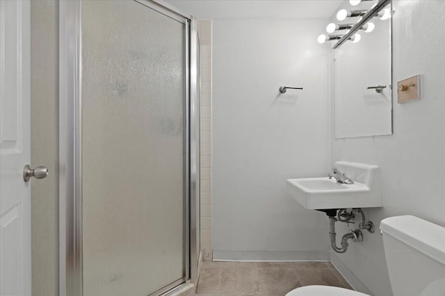 bathroom with toilet and a shower with door