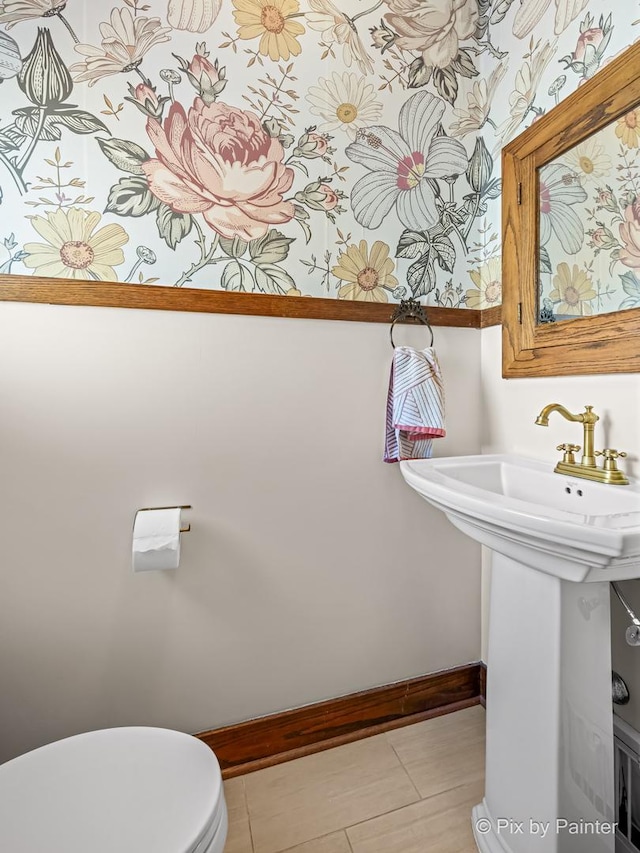 bathroom with sink, toilet, and tile patterned flooring