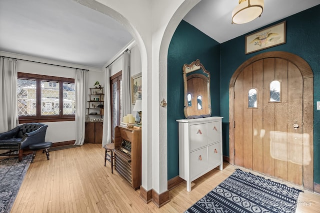 foyer entrance featuring light hardwood / wood-style flooring and ornamental molding