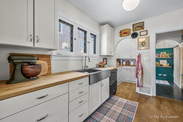 kitchen featuring white cabinets, dishwasher, wooden counters, dark hardwood / wood-style flooring, and sink