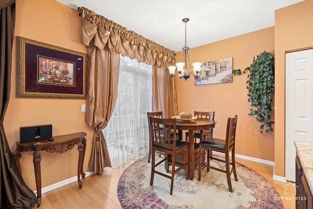 dining area featuring light hardwood / wood-style flooring and a chandelier