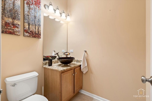 bathroom featuring toilet, vanity, and tile patterned flooring