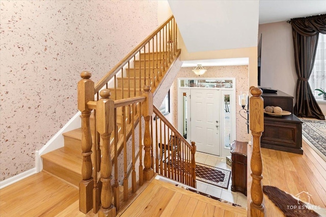 staircase featuring hardwood / wood-style flooring and a high ceiling