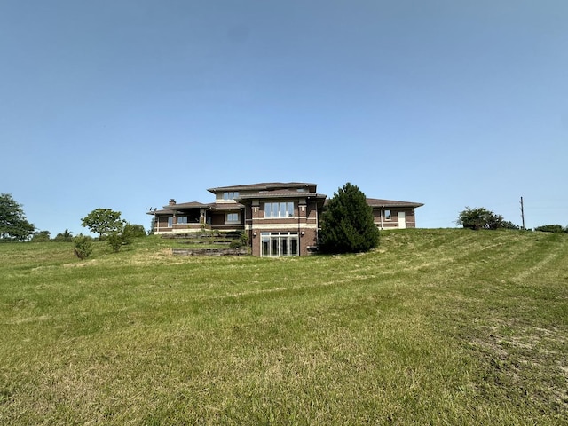 back of property featuring a lawn and a rural view