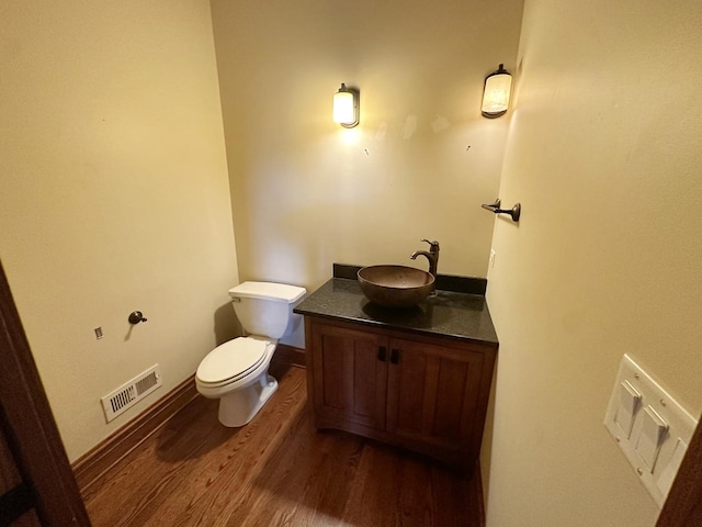 bathroom with vanity, toilet, and wood-type flooring