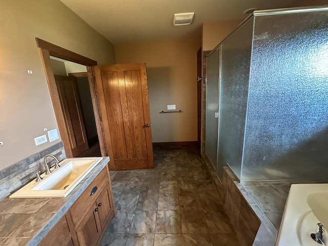 bathroom featuring vanity, walk in shower, and tasteful backsplash