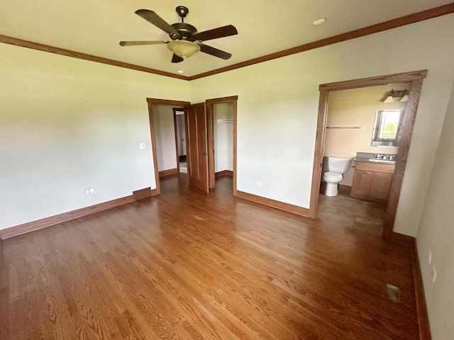 unfurnished bedroom with ensuite bath, ceiling fan, crown molding, and wood-type flooring