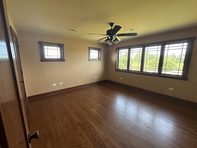 empty room featuring dark hardwood / wood-style floors, ceiling fan, and plenty of natural light