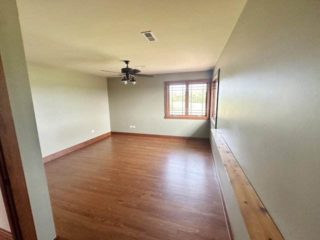 empty room with dark hardwood / wood-style floors and ceiling fan