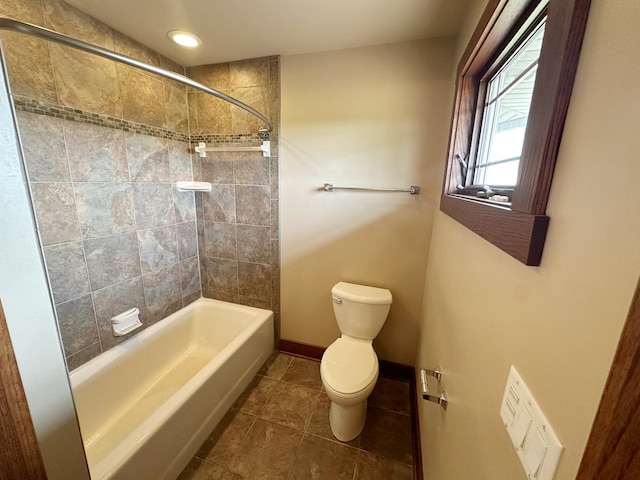 bathroom featuring tile patterned floors, toilet, and tiled shower / bath