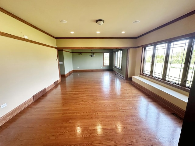 spare room featuring hardwood / wood-style floors, plenty of natural light, and ornamental molding