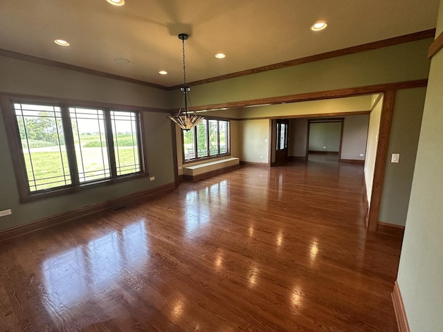 unfurnished dining area with dark hardwood / wood-style floors, an inviting chandelier, and ornamental molding