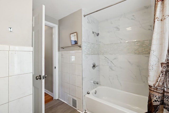 bathroom with tile walls, shower / bath combo, and wood-type flooring