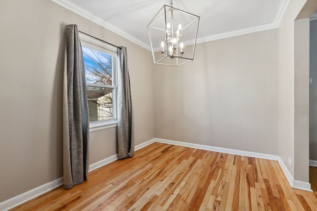 unfurnished dining area featuring crown molding, hardwood / wood-style flooring, and a chandelier