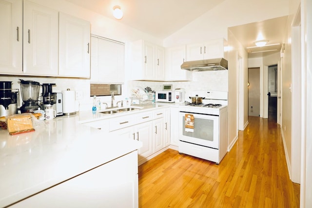 kitchen with white cabinetry, light hardwood / wood-style floors, white appliances, lofted ceiling, and sink