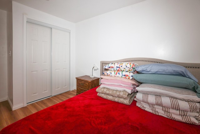 bedroom with hardwood / wood-style floors and a closet