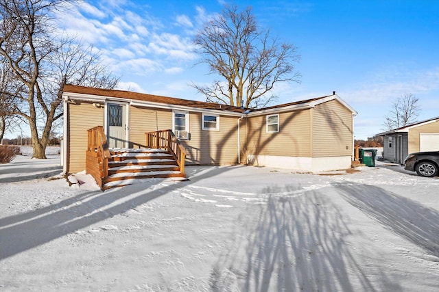 snow covered house featuring cooling unit