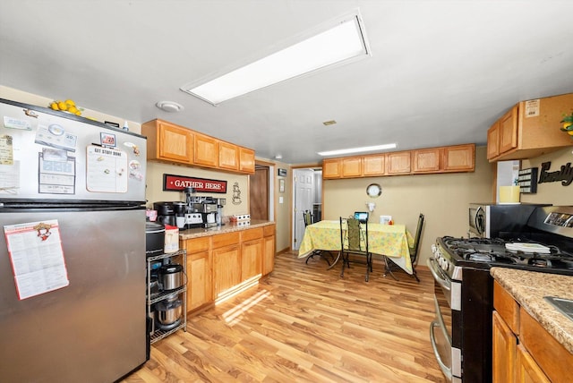 kitchen featuring stainless steel appliances, light hardwood / wood-style floors, and light stone counters