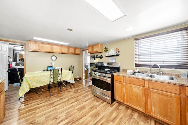 kitchen with sink, light hardwood / wood-style floors, and stainless steel gas range