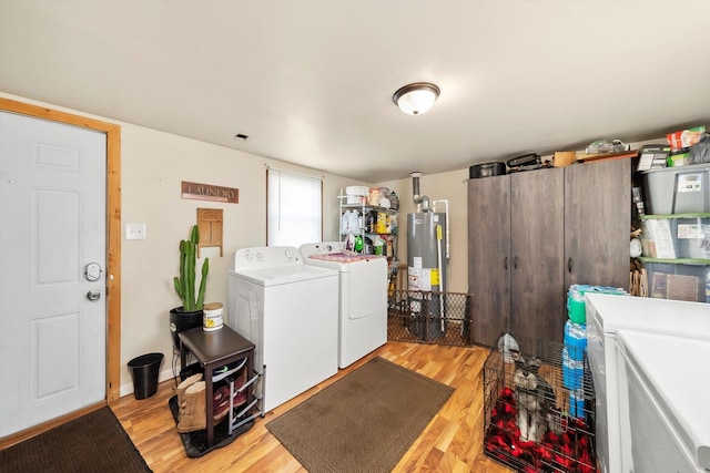 clothes washing area featuring light wood-type flooring, washer and clothes dryer, and gas water heater