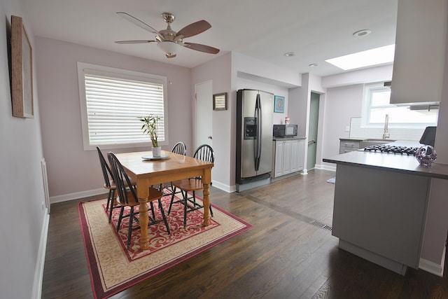 dining room with ceiling fan, sink, and dark wood-type flooring