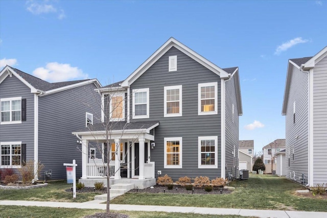 view of front of property featuring covered porch, a front lawn, and central air condition unit