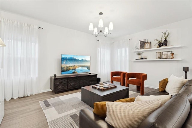 living room with light hardwood / wood-style flooring and a notable chandelier