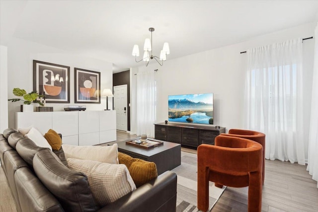 living room featuring light wood-type flooring and a notable chandelier