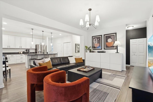 living room featuring light wood-type flooring and a notable chandelier