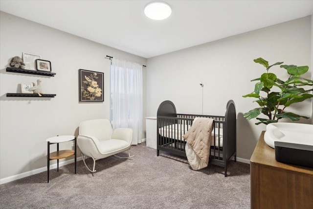 carpeted bedroom featuring a nursery area