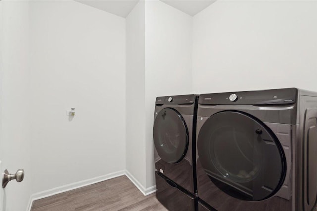 laundry area featuring wood-type flooring and washing machine and dryer