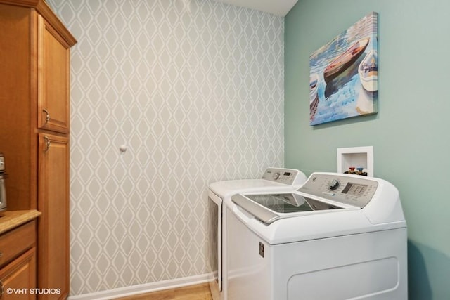 washroom with washer and clothes dryer and cabinet space