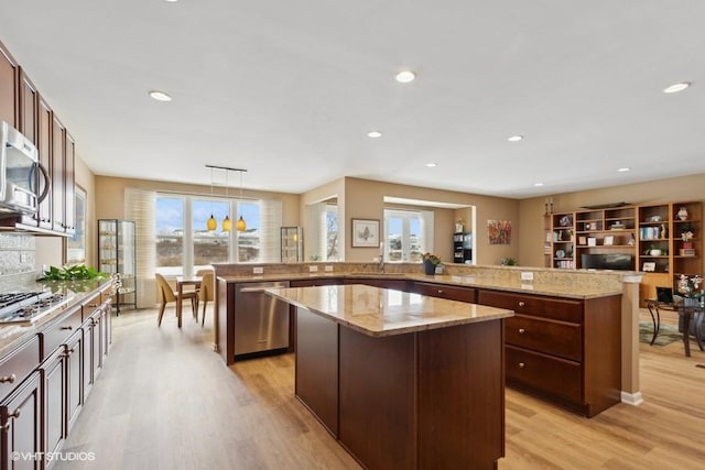 kitchen featuring a large island, a sink, recessed lighting, light wood-style floors, and appliances with stainless steel finishes