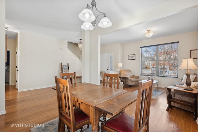 dining area featuring hardwood / wood-style flooring and an inviting chandelier