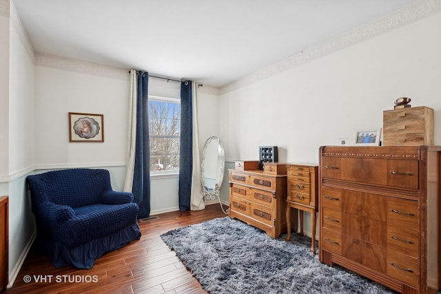 living area with crown molding and hardwood / wood-style flooring