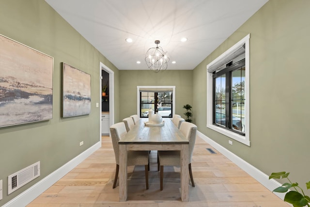 dining room with a chandelier and light hardwood / wood-style flooring