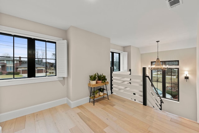 interior space with an inviting chandelier and light hardwood / wood-style flooring