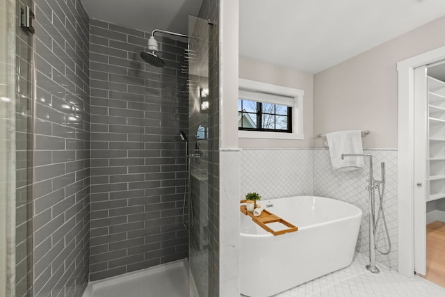 bathroom with tile patterned flooring, shower with separate bathtub, and tile walls