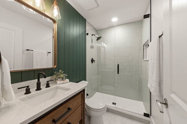 bathroom featuring vanity, toilet, and a shower with shower door