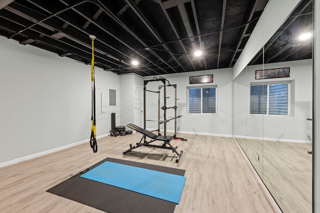 workout room with wood-type flooring and electric panel