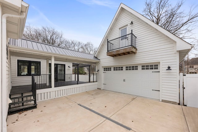 exterior space with a garage, a balcony, and covered porch